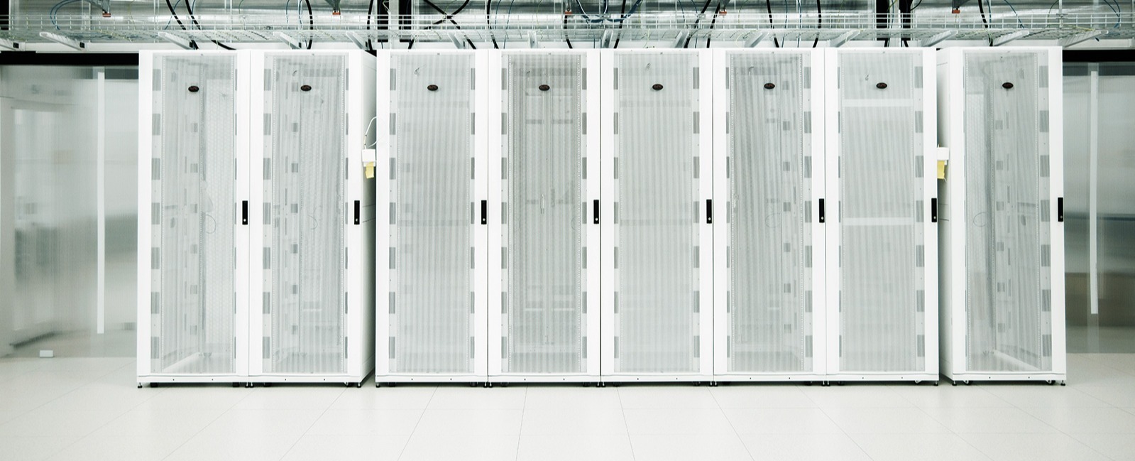 Valkoisten palvelinkaappien rivistöjä datakeskuksen sisällä.