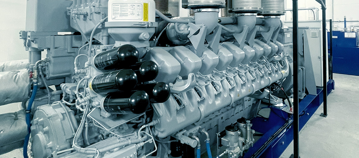 Lähikuva suuresta teollisuusgeneraattorin moottorista laitoksen sisällä.