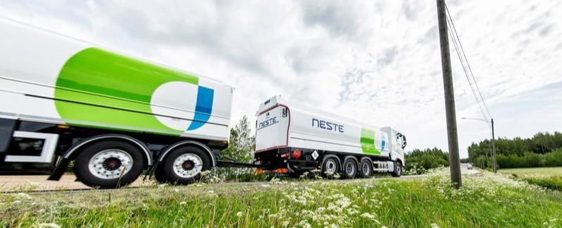 Vihreä HVO100-polttoainekuorma-auto pysäköitynä tielle, jossa on sähkölinjoja.